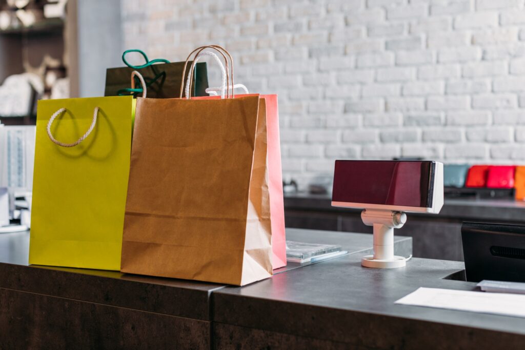 shopping bags standing on cash register in shopping mall, boutique shopping concept